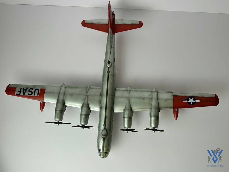 Pu&ograve; includere: Vista dall'alto di un modello di aereo con fusoliera argentata ed estremit&agrave; alari rosse. Le ali hanno quattro motori ed eliche. La coda presenta "USAF" e un'emblema a stella. Replica dettagliata di un aereo d'epoca.