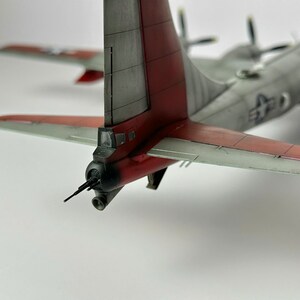 Pu&ograve; includere: Modello dettagliato di aereo con fusoliera grigia e estremit&agrave; alari rosse. Il modello presenta una coda con accenti rossi e una torretta di cannone. L'apertura alare &egrave; di circa 30 cm.