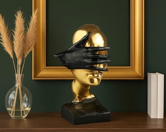 Escultura abstracta de rostro dorado con mano negra: Decoración de arte moderno