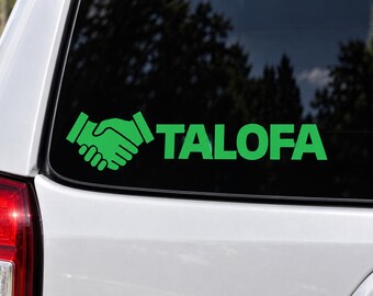 May include: A bright green vinyl decal applied to a car window, featuring a graphic icon of two hands shaking and the word TALOFA in a bold, sans-serif font. The design is positioned horizontally on the dark glass surface of the vehicle.