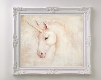 May include: A framed artwork depicting a white unicorn with a golden horn and flowing mane. The painting has a soft, pastel colour palette and is set in a white ornate frame. The artwork is a fantasy-themed piece.