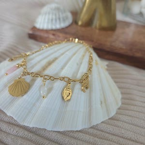 Women&#39;s bracelet with gold-plated stainless steel charms. Charm and elegance