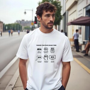 Peut inclure: T-shirt blanc avec le texte "THINGS I DO IN MY SPARE TIME" et des illustrations de bus. Les illustrations représentent conduire, parler de, se souvenir de, rêver de, penser à et regarder un bus. Le t-shirt est porté par une personne.