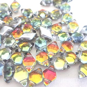 May include: A collection of iridescent glass beads in shades of blue, green, yellow, and red. The beads are faceted and have a diamond shape.