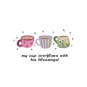 May include: An embroidered design featuring three decorative coffee cups. The first cup is pink with hearts, the second is striped, and the third is green with floral details. The text "my cup overflows with his blessings!" is below.