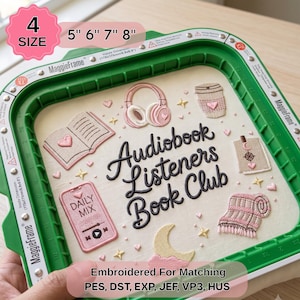 Peut inclure: Un cadre à broder vert MaggieFrame contenant un tissu avec le texte brodé 'Audiobook Listeners Book Club' entouré d'icônes de casque, un livre, une tasse de café, un téléphone avec 'DAILY MIX', une lune et une couverture.