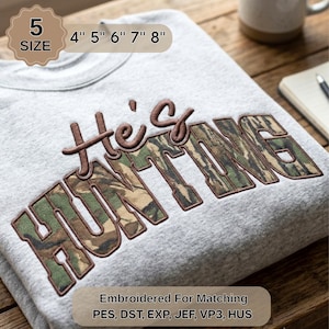 May include: A light gray sweatshirt featuring the embroidered text He's HUNTING in brown and camouflage patterns. The design includes a label indicating 5 sizes ranging from 4 to 8 inches and lists file formats PES, DST, EXP, JEF, VP3, and HUS.