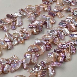 Op de afbeelding: Close-up van iriserende, onregelmatig gevormde zoetwaterparels in tinten roze, lavendel en crème. De parels hebben een natuurlijke, organische vorm en een glanzende glans. Ideaal voor het maken van sieraden.