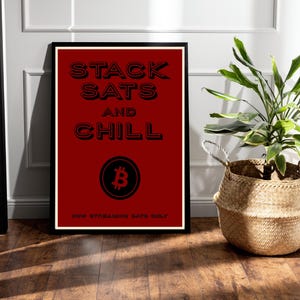 Puede incluir: Un póster rojo enmarcado con las palabras "STACK SATS AND CHILL" en negro, con un símbolo de Bitcoin. La frase "HOW STREAMING SATS ONLY" está en la parte inferior. Una cesta tejida con una planta verde está a la derecha.