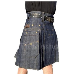 Pode incluir: Um kilt de ganga escura com um cinto preto com tachas. O kilt apresenta vários bolsos com fechos de botão de latão e tachas decorativas de latão. O kilt tem um design plissado e um remendo de couro.