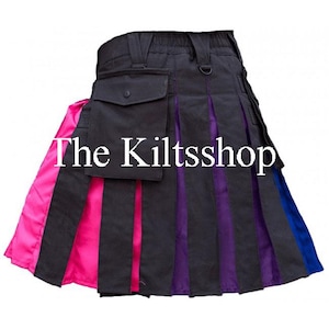 Op de afbeelding: Een zwarte kilt met plooien en zakken, met roze, paarse en blauwe panelen. De tekst "The Kiltsshop" staat op de voorkant. Dit kledingstuk is ontworpen voor een unieke en kleurrijke stijl.