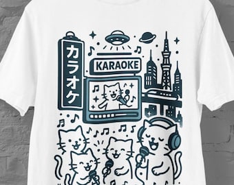 Könnte beinhalten: Weißes T-Shirt mit einer blauen Grafik von singenden Katzen beim Karaoke. Das Design beinhaltet japanischen Text, Noten, eine Stadtlandschaft und die Worte "UTANEKO CITY". Das Shirt hat einen Rundhalsausschnitt und kurze Ärmel.