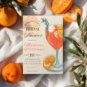 May include: A bridal shower invitation featuring a watercolor illustration of a cocktail with orange slices. The invitation includes the text "Please join us for a Bridal Shower" and details for Madison Williams' shower on June 19th.
