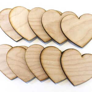 May include: Ten unfinished wooden heart shapes, perfect for crafting and DIY projects. The hearts are natural wood color with a smooth surface.