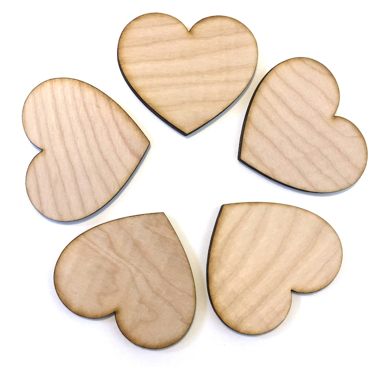 May include: Five unfinished wooden heart shapes arranged in a circle. The hearts are all the same size and shape, and they are made of a light brown wood.