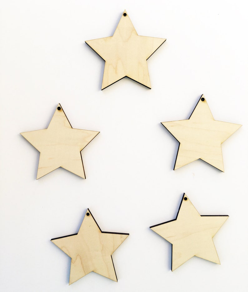 Pu&ograve; includere: Cinque stelle di legno non finite con un foro in cima. Le stelle sono tutte della stessa dimensione e forma, e sono disposte in uno schema sfalsato.