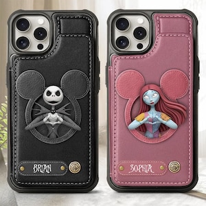 Puede incluir: Dos fundas para teléfono con textura similar al cuero. Una es negra con un diseño de Jack Skellington, la otra es rosa con un diseño de Sally. Ambas fundas tienen una ranura para tarjetas y los nombres "BRIAN" y "SOPHIA" están impresos en ellas.