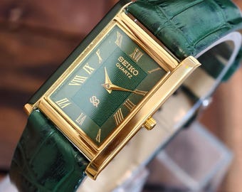 Reloj Seiko Slim Tank Quartz Vintage, caja rectangular chapada en oro, esfera verde con números romanos.