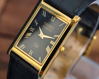 Reloj Seiko vintage de cuarzo delgado con esfera rectangular negra y números romanos. Reloj clásico.