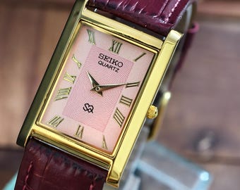 Reloj Seiko Tank vintage: caja rectangular chapada en oro, esfera rosa con números romanos. Reloj unisex.