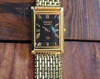 Reloj de pulsera vintage Seiko Slim Tank de cuarzo para hombre con esfera negra con números romanos y baño de oro.