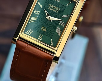 Reloj vintage Seiko Slim Tank de cuarzo con esfera verde con números romanos y caja rectangular chapada en oro.