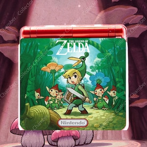 May include: A red Nintendo Game Boy Advance SP handheld gaming console featuring a green forest-themed decal on the lid. The decal displays The Legend of Zelda logo, a central character holding a sword and shield, and several small forest creatures.