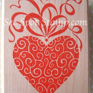 May include: Red rubber stamp with a heart-shaped design. The heart is filled with a swirling pattern and has a bow at the top. The text "See Spot Stamp.com" is printed in the top right corner.