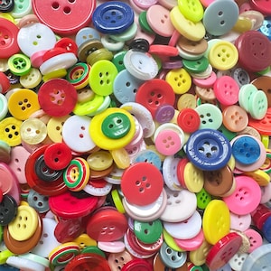 以下が含まれることがあります： さまざまなサイズと形状のカラフルなボタンの活気ある品揃え。ボタンは赤、黄、緑、青、ピンク、白の色合いです。2つの穴があるボタンもあれば、4つの穴があるボタンもあります。プラスチックと樹脂のボタンの混合です。