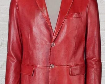 Puede incluir: Una americana de cuero rojo vibrante con solapa de muesca, dos botones frontales, mangas largas y dos bolsillos con solapa en la cintura. La prenda incluye un bolsillo en el pecho en el lado izquierdo y un acabado liso y estructurado.