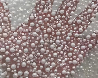 May include: A sheer fabric overlay densely embellished with a multitude of small, round, white and iridescent beads. The beads are arranged in a scattered pattern across the translucent material, creating a textured surface with a subtle shimmer.