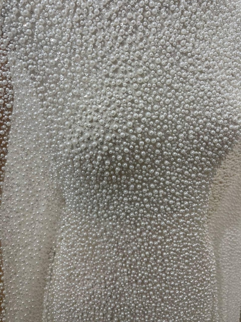 soft ivory tulle, pearl beaded tulle, pearls various sizes, bridal pearl fabric, wedding dress fabric, beaded mesh fabric, ivory bridal mesh, pearl embroidery fabric, couture bridal material, luxury beaded tulle, wedding sewing fabric, bridal corset fabric, bodice fabric, veil fabric, pearl applique fabric, dense pearl beading, embellished tulle, bridal designer fabric, hand sewn pearls fabric, ivory mesh fabric, gown making fabric, wedding textile, pearl wedding fabric.