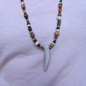 May include: A necklace made of various colored wooden beads with a white antler pendant.