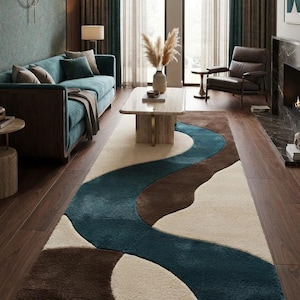 May include: A rectangular area rug featuring a wavy, abstract pattern in deep teal, dark brown, and cream. The rug has a thick, plush texture and covers a portion of the dark wood floor, showcasing curved color-blocked sections throughout.