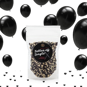 Better Off Single popcorn kernel bag on white surrounded by black balloons and black heart confetti. Dell Cove Spices
