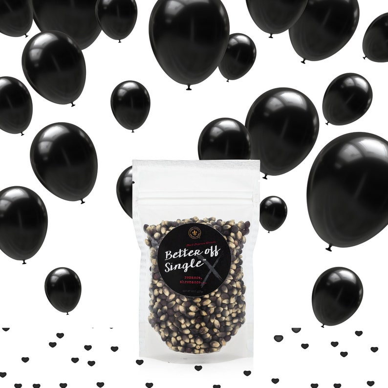 Better Off Single popcorn kernel bag on white surrounded by black balloons and black heart confetti. Dell Cove Spices