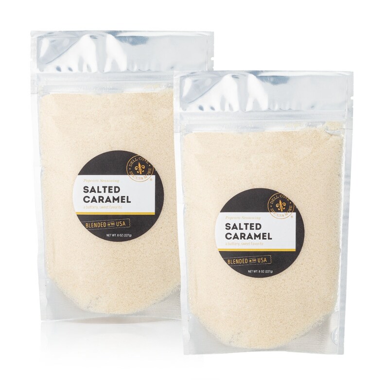 May include: Two clear plastic pouches containing a white powder labeled "Salted Caramel" with a black and gold logo. The pouches are on a white background.