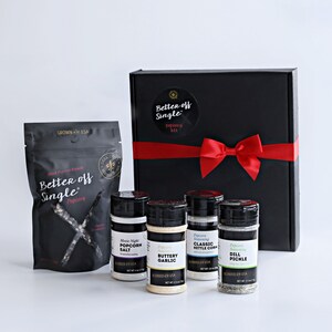 May include: A black gift box tied with a red ribbon and bow, with a "Better Off Single" label. Includes a bag of popcorn and four seasoning jars: Movie Night Popcorn Salt, Buttery Garlic, Classic Kettle Corn, and Dill Pickle.