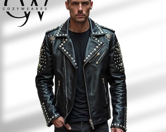 Puede incluir: Chaqueta de cuero negra con tachuelas y cremalleras plateadas. La chaqueta tiene un estilo motero clásico con cuello de solapa y charreteras. La marca "COZYWEARSS" es visible en la esquina superior izquierda.