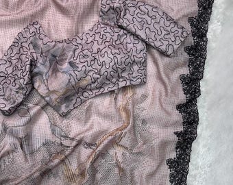 Könnte beinhalten: Ein hellrosa Sari mit schwarzem floralem Spitzenbesatz. Der Sari verfügt über einen passenden Stoff für Bluse und Ärmel mit einem schwarzen abstrakten Design. Die Bluse hat einen detaillierten Druck eines Vogels und eines floralen Designs.