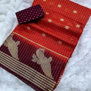 May include: A vibrant red and burgundy textile with gold accents. The fabric features a grid pattern and gold polka dots. A matching burgundy fabric with gold polka dots is also included. The textile has a decorative gold bird design.