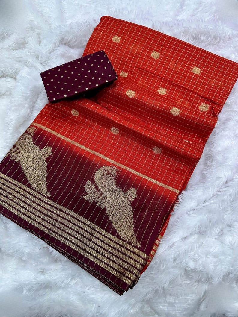 May include: A vibrant red and burgundy textile with gold accents. The fabric features a grid pattern and gold polka dots. A matching burgundy fabric with gold polka dots is also included. The textile has a decorative gold bird design.