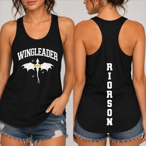 May include: A black racerback tank top featuring the white text WINGLEADER above a white and gold dragon graphic on the front, and the white text RIORSON printed vertically in a block font on the back of the garment.