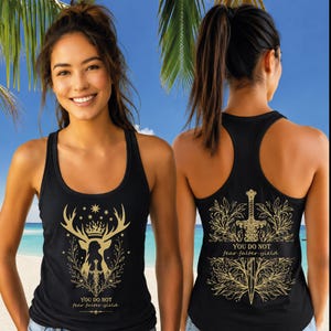 May include: Black tank top with a gold deer design, crown, and text "YOU DO NOT fear falter yield" on the front. The back features a gold sword design and the same text. The tank top is sleeveless and has a racerback style.