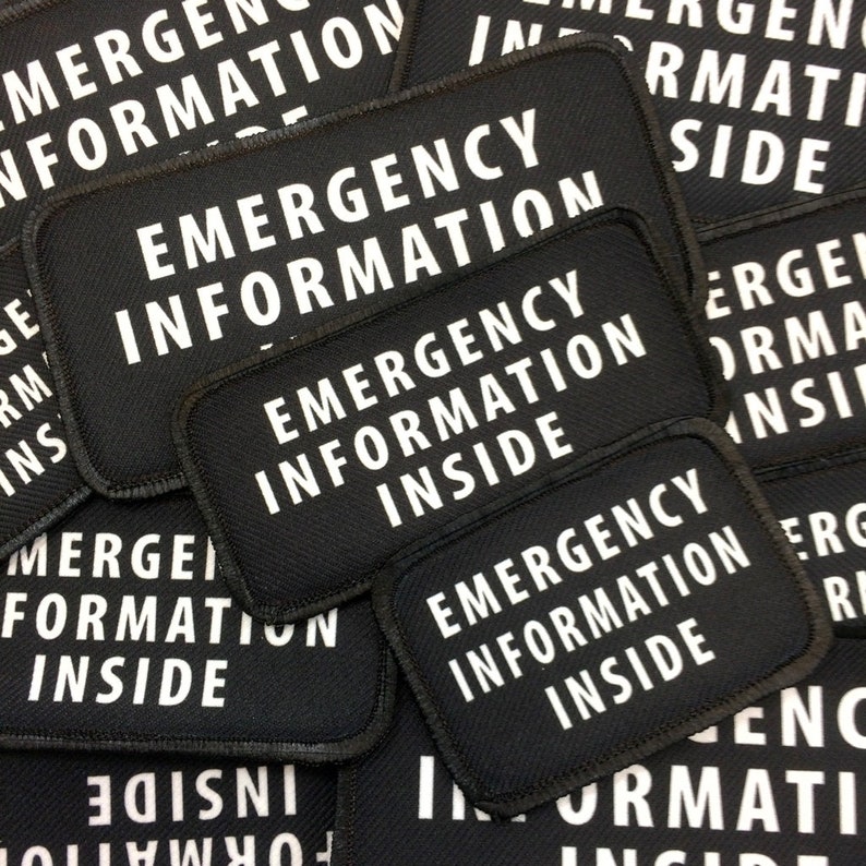 Puede incluir: Primer plano de varios parches de tela negra con texto blanco que dice "Emergency Information Inside".
