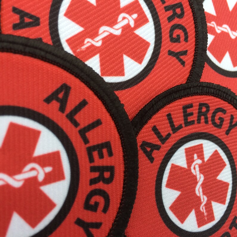 May include: Red and white allergy alert patches with a black border and the word "ALLERGY" printed in black. The patches feature a red star of life symbol with a white snake wrapped around it.