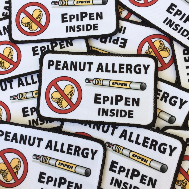 May include: A stack of white patches with black borders, each with a red circle with a peanut inside, a black and white drawing of an EpiPen, and the text "Peanut Allergy" and "EpiPen Inside".