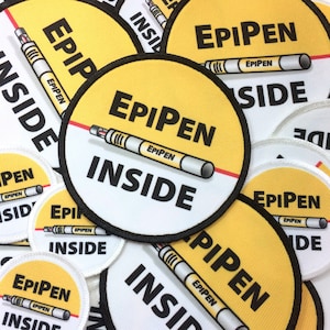 May include: A collection of yellow and white round patches with black text and a red line. The text on the patches reads "EPIPEN INSIDE".