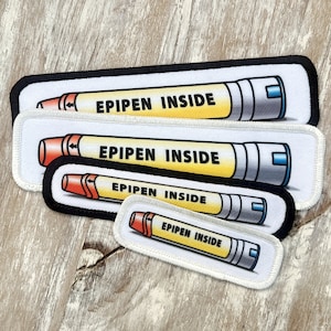 May include: Four white fabric patches with black borders, each featuring a cartoon image of an EpiPen with the text "EPIPEN INSIDE" in yellow letters.