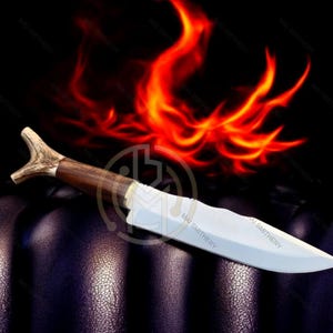 May include: A handcrafted knife with a wooden handle and a polished blade. The handle features a unique antler design. The knife is set against a dark background with a fiery orange and red graphic, creating a dramatic effect.